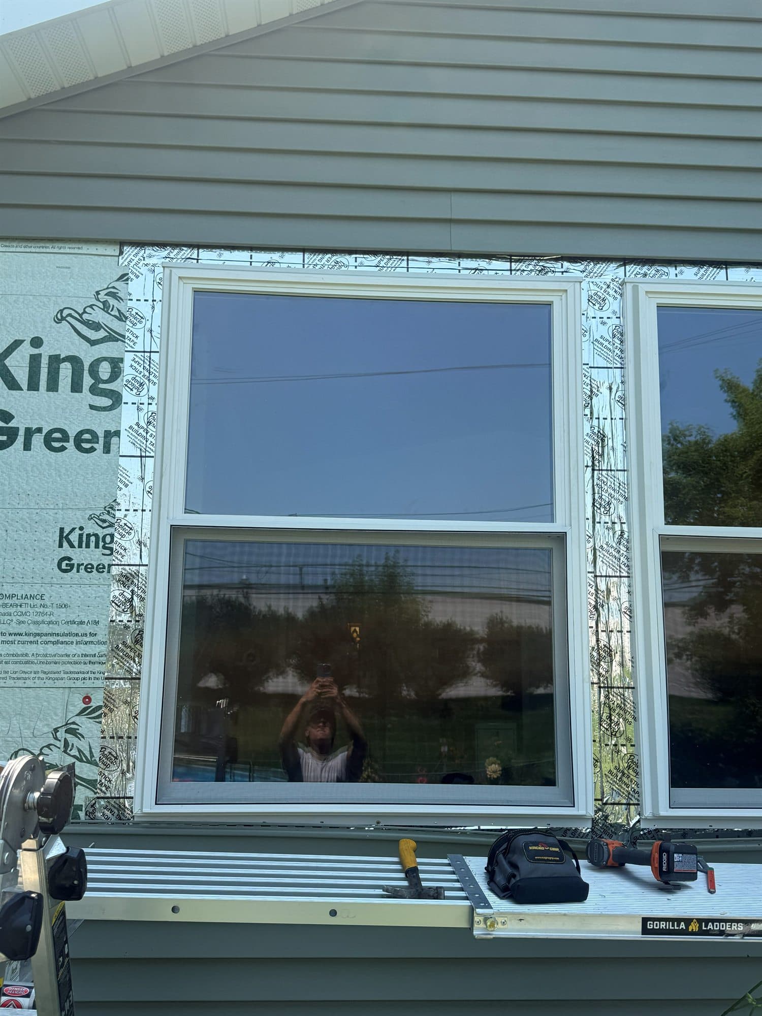 New white double-hung windows installed and taped on a new construction home