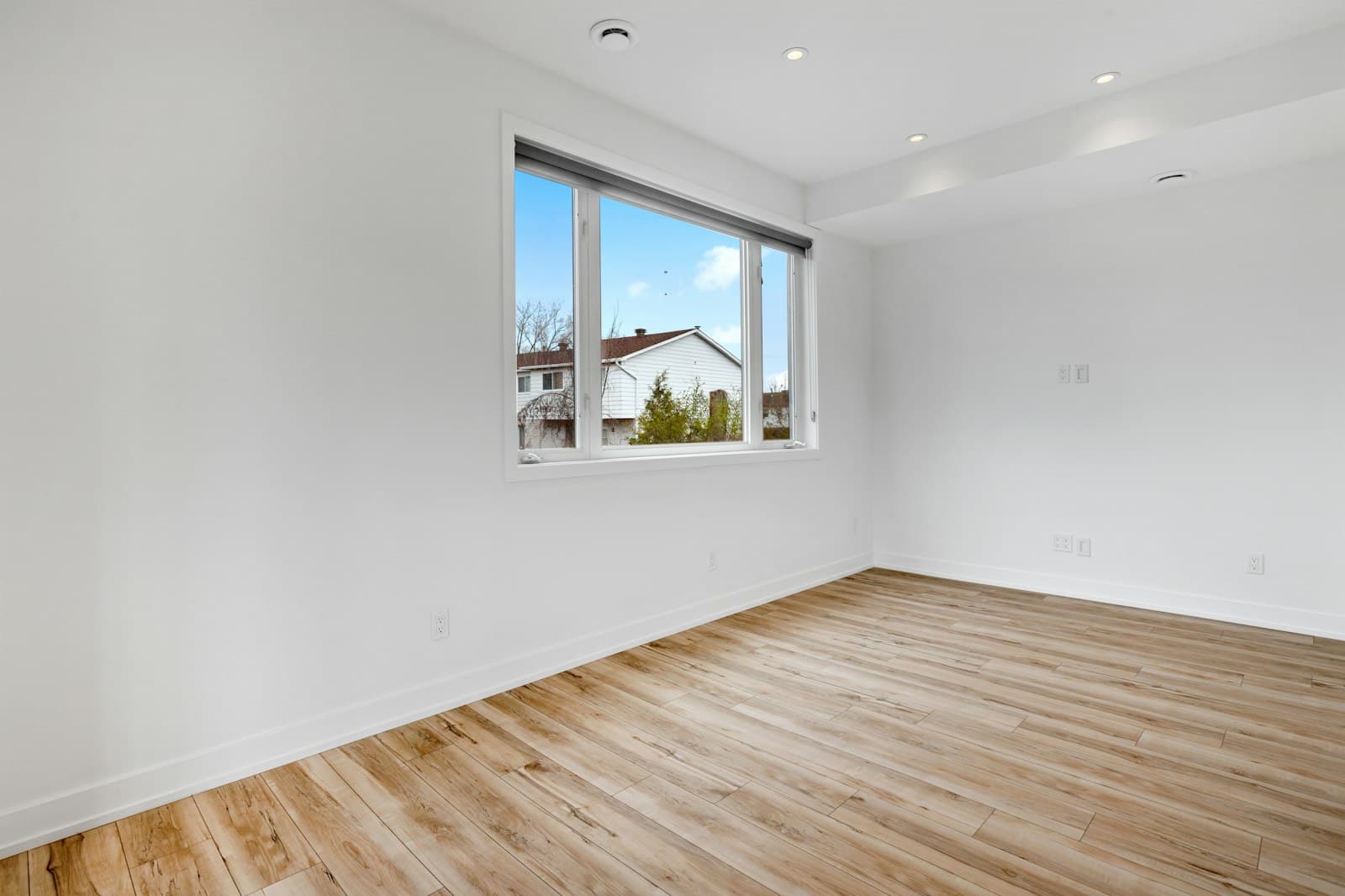 Cleared room with wood floors and bright windows