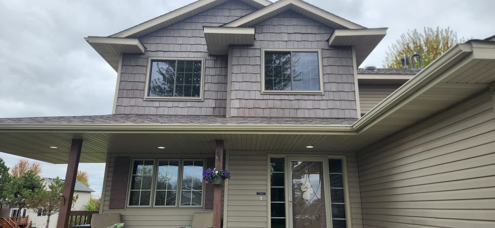 Twin Cities two-story home with new grid windows and a glass-panel entry door installed by JMB Builders